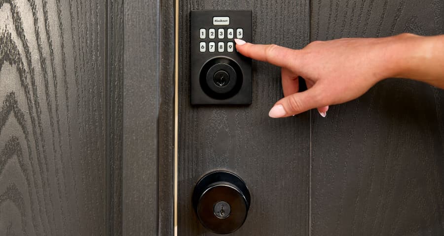 Finger pushing the keypad of a Vivint smart lock