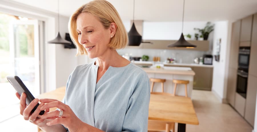 Woman holding a mobile device in a stylish home